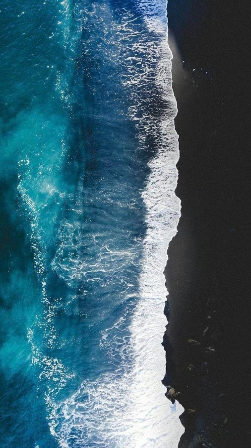 Horizon's Convergence: Turquoise Waves on Black Sands
