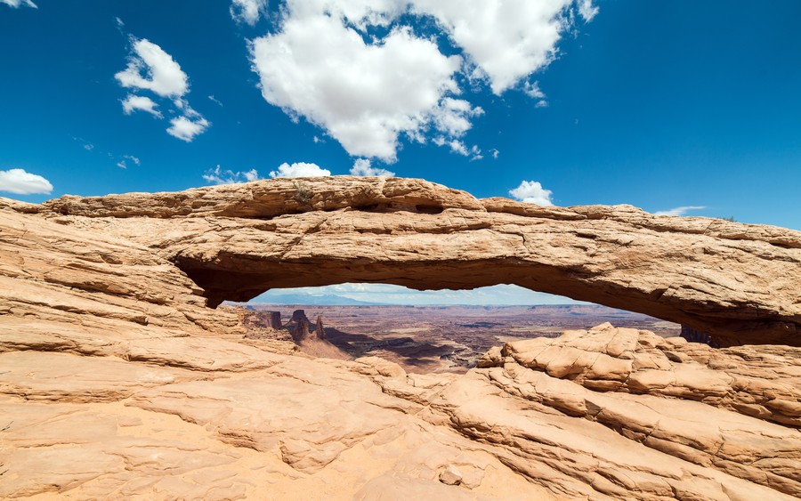 Desert Solitude: Majestic Rock Arch Under an Infinite Sky