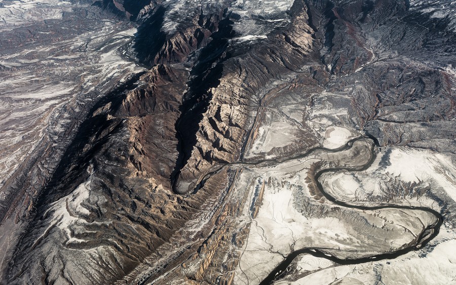 Aerial Majesty: The Undulating Tapestry of Desert Canyons and River Systems