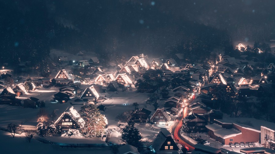 Enchanted Winter's Embrace: Traditional Snowy Village Under a Starry Mountain Sky