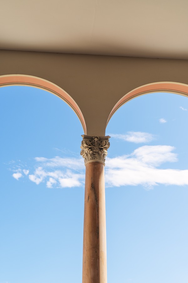 Ethereal Ascension: Majestic Stone Column Against a Vast Blue Sky