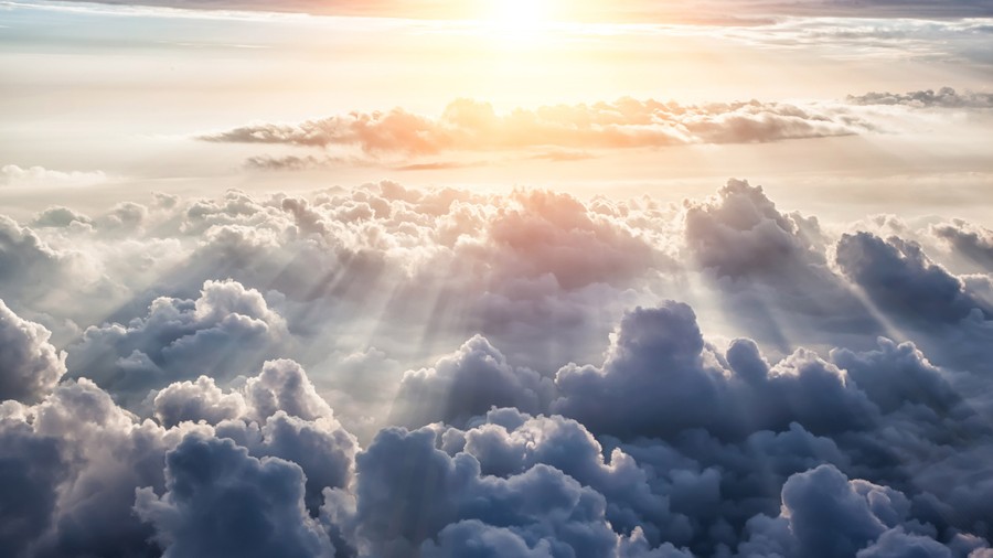 Radiant Dawn: Sunrays Illuminating Ethereal Clouds