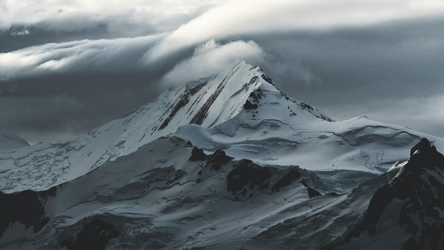 Majestic Snow-Crowned Peak Under a Stormy Sky