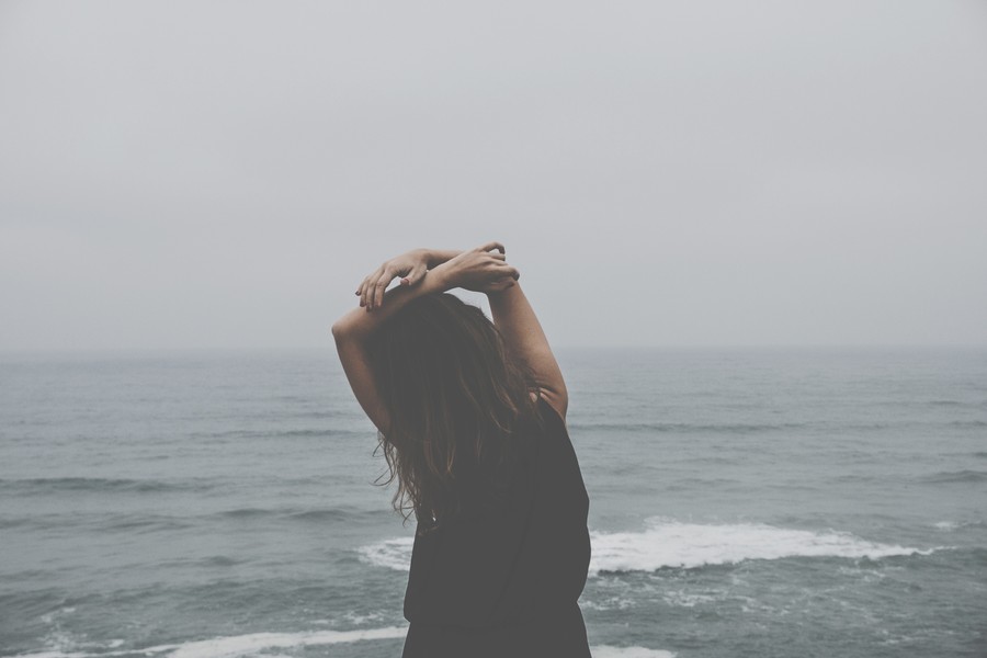 Solemn Tides: A Contemplative Moment by a Stormy Sea