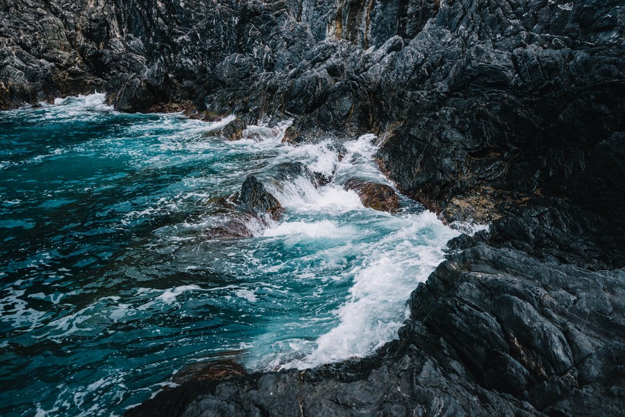 Crashing Turquoise Waves Against Jagged Shores