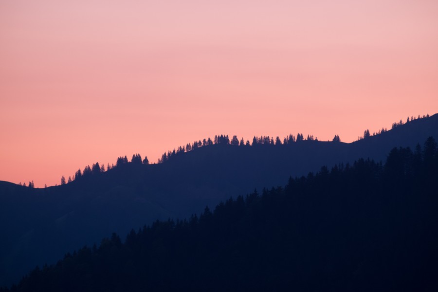Twilight Serenity: Pink Hues Over Silhouetted Peaks