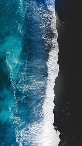 Horizon's Convergence: Turquoise Waves on Black Sands - خلفية لطيفة