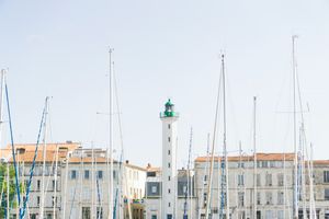 Coastal Serenity: White Lighthouse Amidst Sails and Charming Architecture - Cute Wallpaper
