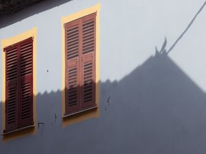 Rustic Charm: Sunlit Shutters on a Serene Wall - Niedliches Hintergrundbild