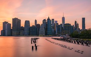Serene Symphony of Lights: A Sunset Skyline Over Calm Waters - Niedliches Hintergrundbild