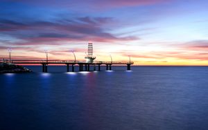Tranquil Sunset Reflections Over Waterfront Pier with Pier Lighthouse - Söt tapet